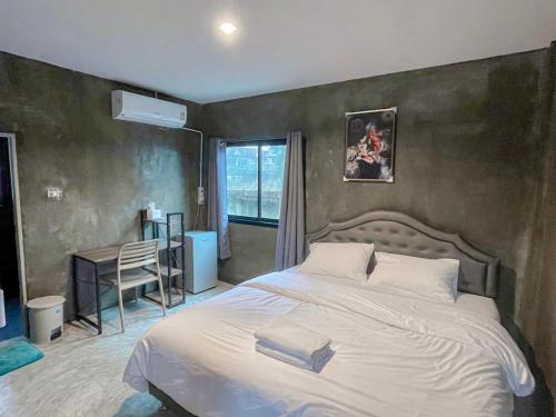 a bedroom with a large white bed and a window at Taweehome hotel in Phra Nakhon Si Ayutthaya