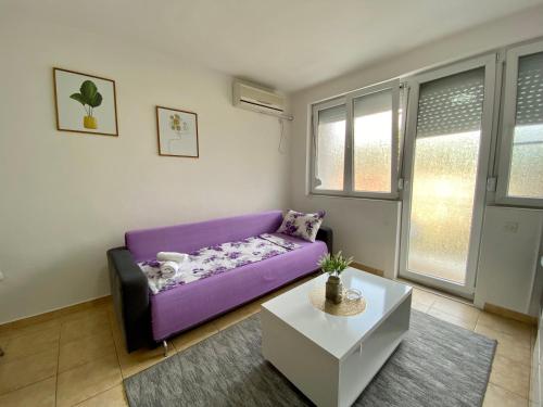 a purple couch in a living room with a table at Central DELUXE Apartment in Prilep