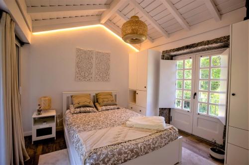 a bedroom with a bed and a large window at COUNTRY HOUSE by the RIVER - NATIONAL PARK in Arcos de Valdevez
