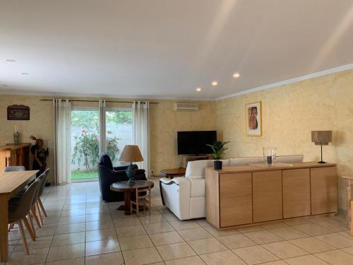 sala de estar con sofá blanco y TV en Villa proche cap d’agde en Bessan