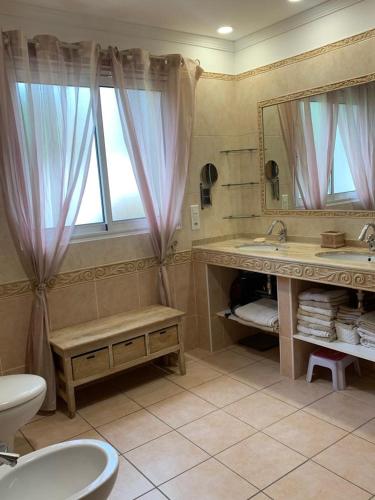 une salle de bain avec un lavabo, des toilettes et un miroir dans l'établissement Villa proche cap d’agde, à Bessan