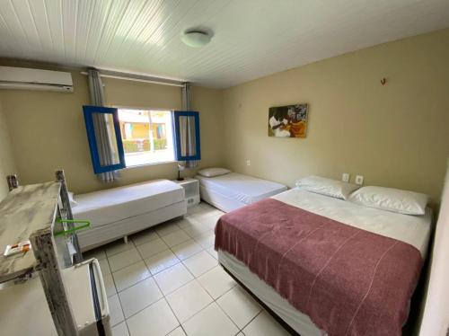 a bedroom with two beds and a window at Pousada Hippopotamus Jeri in Jericoacoara