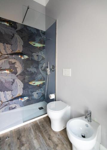 a bathroom with a toilet and a wall with fishes at Household Settembrini in Milan