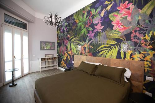 1 dormitorio con cama y pared de flores en Household Settembrini, en Milán