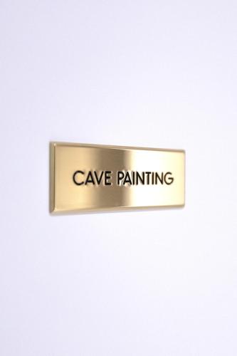 a sign that says cave painting on a white wall at Household Settembrini in Milan