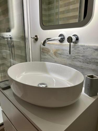 a white sink in a bathroom under a mirror at G&W Luxury Rooms in Athens