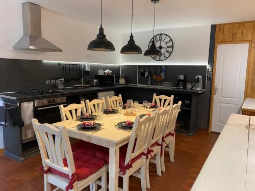 a kitchen with a white table and chairs in a kitchen at Gîte Edelweiss Saint-Martin-en-Vercors in Les Barnoux