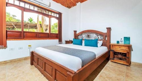 - une chambre avec un grand lit et une fenêtre dans l'établissement Hotel Casa Baquero, à Villavicencio