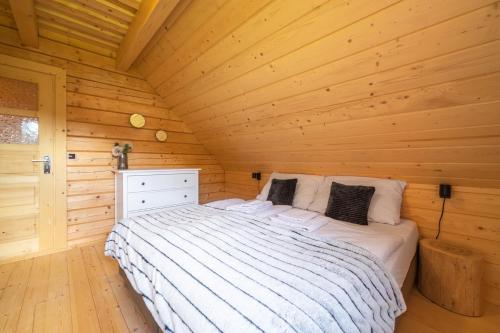 a bedroom in a log cabin with a bed at Dvě chalupy - Velké Karlovice in Velké Karlovice