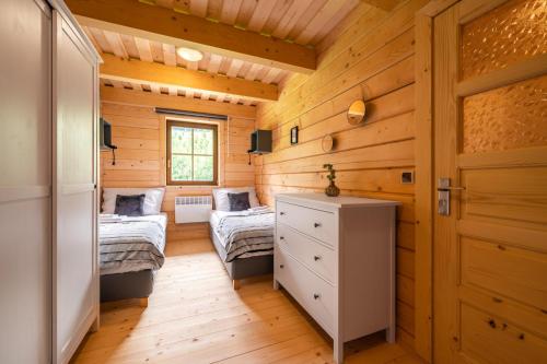 um quarto com 2 camas numa casa de madeira em Dvě chalupy - Velké Karlovice em Velké Karlovice