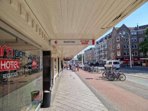 un edificio en una calle de la ciudad con bicicletas estacionadas en la acera en Amigo Hotel, en Ámsterdam