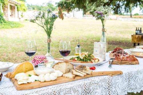 a table with wine glasses and food on it at Tre Cercole - Eco Resort in San Marco in Lamis