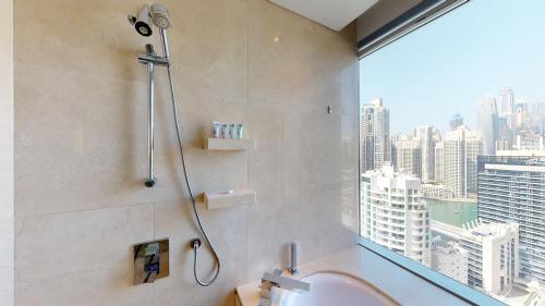 a bathroom with a shower and a sink and a window at Key View - Emaar Residences, Marina Mall in Dubai