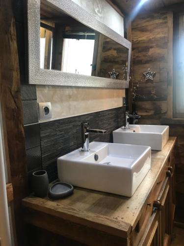 Un baño con dos lavabos y un espejo. en LE GALTA Chalet Lucie, en Valmorel