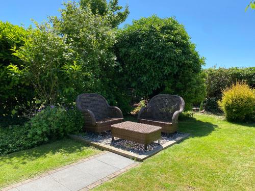 two wicker chairs and a table in a yard at Thatch Cottage, East Boldre nr Beaulieu and Lymington in Brockenhurst