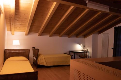 Zimmer mit 2 Betten und einem Tisch mit einer Lampe in der Unterkunft Al Settimo Miglio, alloggio agrituristico in Treppo Grande