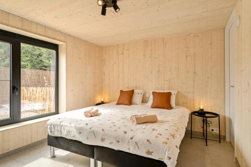 1 dormitorio con 1 cama con 2 toallas en Chalet Babette, en Koksijde
