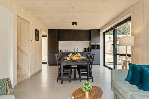 a kitchen and living room with a table and chairs at Chalet Babette in Koksijde