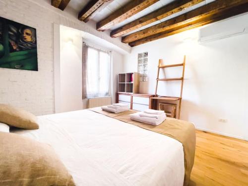 een slaapkamer met een groot bed en 2 handdoeken bij [ARCO DELLA PACE - SEMPIONE] - Moderno Bilocale in Milaan