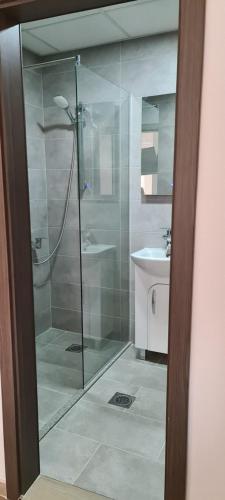 a glass shower in a bathroom with a sink at G&G Suites in Ohrid