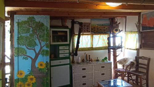 a kitchen with a tree painted on the wall at Casetta sull'Albero, Girasole in Castellammare del Golfo