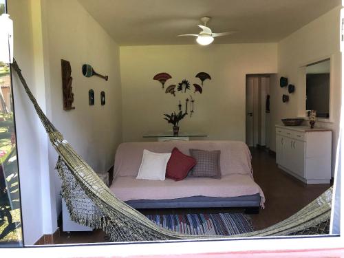 a hammock in a room with a bed and a kitchen at Natureza e mar no Bracuhy in Angra dos Reis