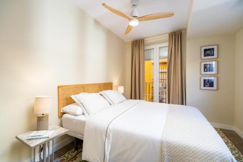 a bedroom with a white bed and a ceiling fan at Sherryflat Alma in Jerez de la Frontera