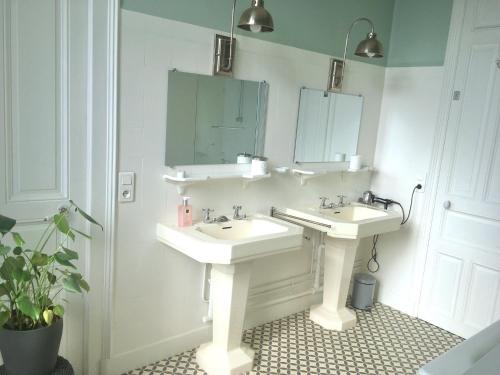 ein Badezimmer mit 2 Waschbecken und einem Spiegel in der Unterkunft Villa Joséphine in Brienne-le-Château