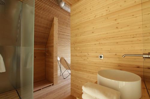 uma casa de banho com um WC e um chuveiro com paredes de madeira em LILELO - Little Leisure Lodge em Grazzano Badoglio