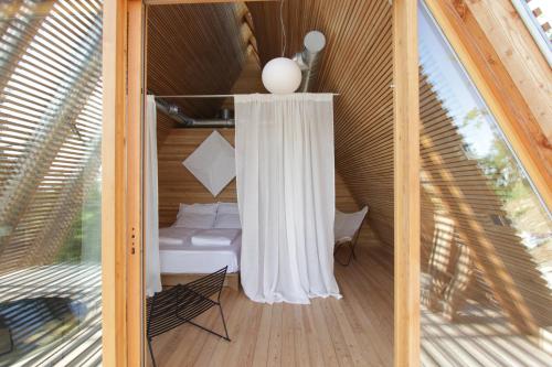 a room with a bed and a curtain on a porch at LILELO - Little Leisure Lodge in Grazzano Badoglio