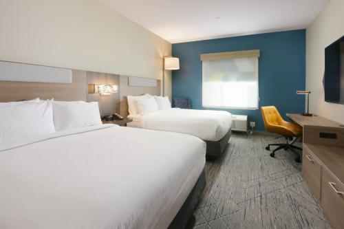 Holiday Inn Express & Suites - Williamstown - Glassboro, an IHG Hotel في ويليامزتاون: غرفة فندقية بسريرين ومكتب