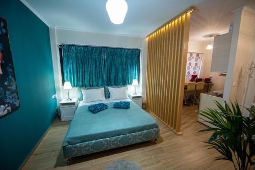 a bedroom with a bed and a blue wall at Efie's Studio in Kalamata