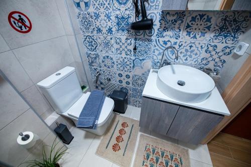 a bathroom with a white toilet and a sink at Efie's Studio in Kalamata