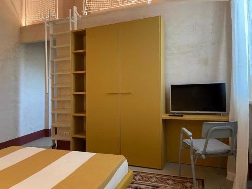 a bedroom with a bed and a desk with a tv at LABottega - Camere in Marina di Pietrasanta