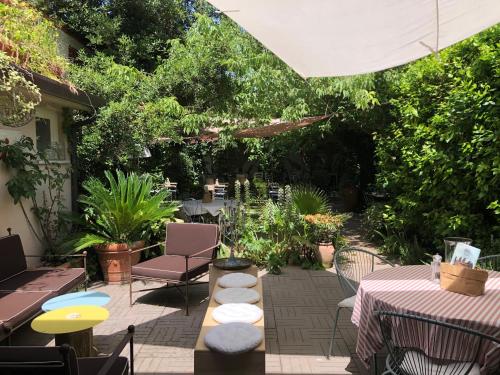 een patio met tafels, stoelen en planten bij LABottega - Camere in Marina di Pietrasanta