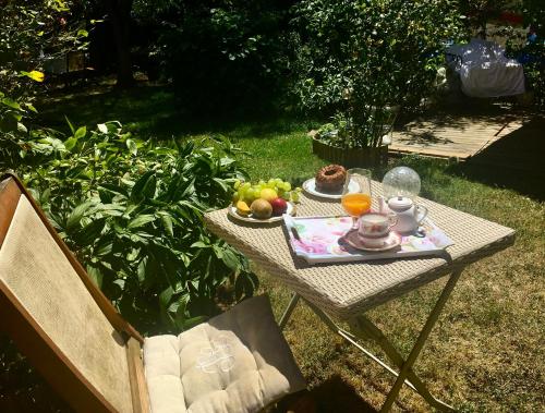 una mesa de picnic con un plato de fruta. en Le Havre de paix, en Saint-Cyr-sur-Loire