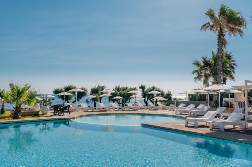 uma piscina com espreguiçadeiras e guarda-sóis em Canne Bianche Lifestyle Hotel em Torre Canne