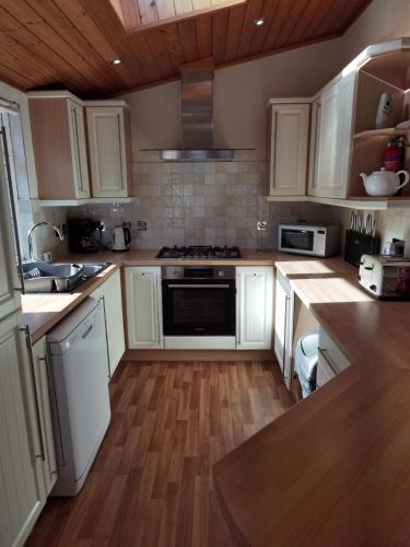 a kitchen with white cabinets and a stove top oven at Bonnie Banks Lodge Ardlui in Ardlui