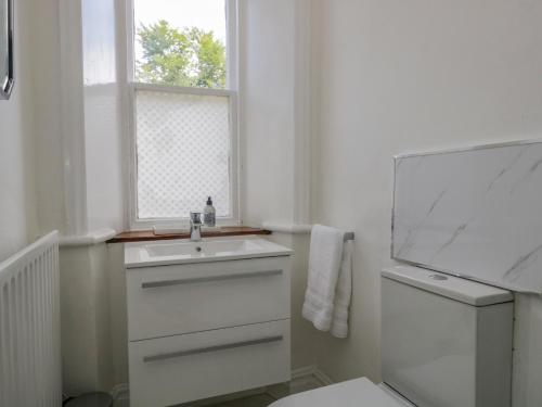 The Residence في Cleator: حمام أبيض مع حوض ونافذة