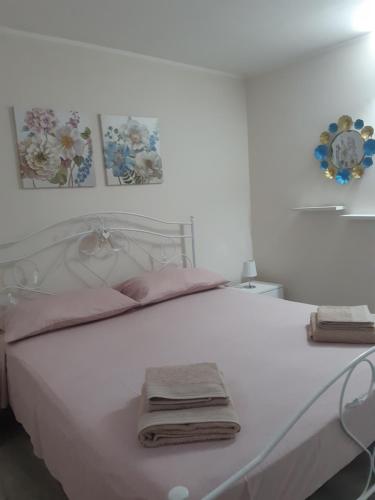 een wit bed met twee vouwhanddoeken erop bij Villetta 4 Colonne in Nardò