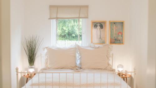 a bedroom with a white bed with a window at Apartment Bonbon - stilvoll renoviert - Ihr zu Hause auf Zeit in Kassel