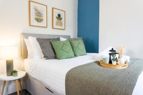 a bedroom with a bed with green and white pillows at Air Host and Stay - Conningsby House - Beautiful 6 bedroom sleeps 14 minutes to LFC in Liverpool