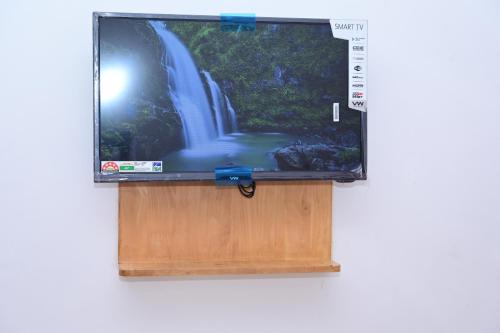a flat screen tv with a waterfall on the screen at Hotel Stay Shine in Mysore