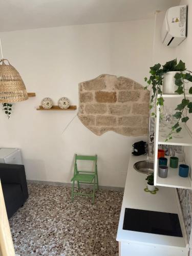 a kitchen with a green chair in a room at Dimora La Terrazza in Polignano a Mare