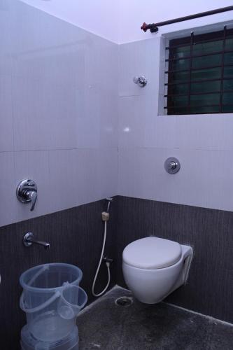 a bathroom with a toilet and a shower at Hotel Stay Shine in Mysore