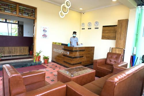 a man standing at a bar in a waiting room at Hotel Stay Shine in Mysore