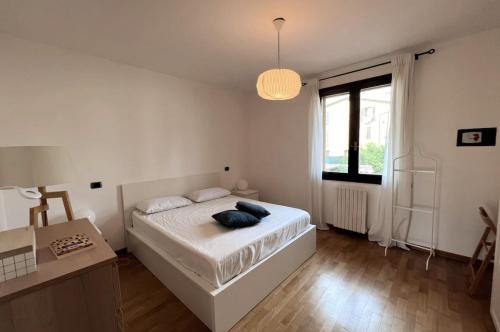 um quarto branco com uma cama e uma janela em San Martino Apartment - Moniga del Garda em Moniga