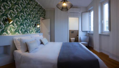 een slaapkamer met een groot wit bed en een groene muur bij Palazzo Belli Roma in Rome