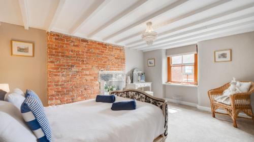 a bedroom with a brick wall and a bed at Bobbin Cottage in Belper