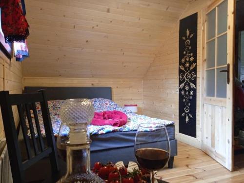 a room with a bed with a table with a glass of wine at Domek na grapie in Gilowice